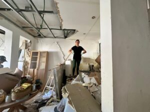 This photo shows the extensive interior destruction caused by an Iranian missile strike, as the resident navigates through the ruins of what was once her home and media studio.